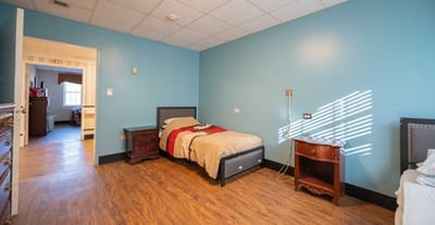 A simple private resident room with a bed and furniture
