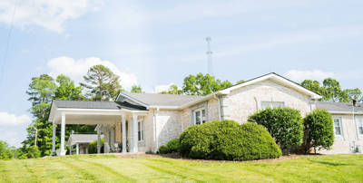Exterior view of a senior care facility surrounded by greenery