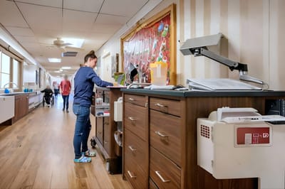 Staff member assisting in a facility hallway
