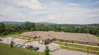 The Landings of Mills River, assisted living in Mills River, NC — Senior living facility surrounded by green mountains and parking