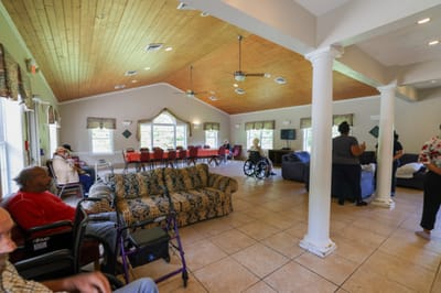 Residents relaxing in a large common area of the facility