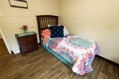 A cozy resident room with a colorful bedspread and decor