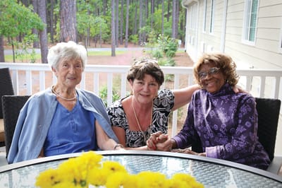 Three residents enjoying time together on a patio
