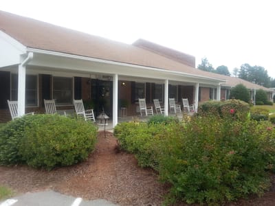 Exterior view of an assisted living facility with rocking chairs