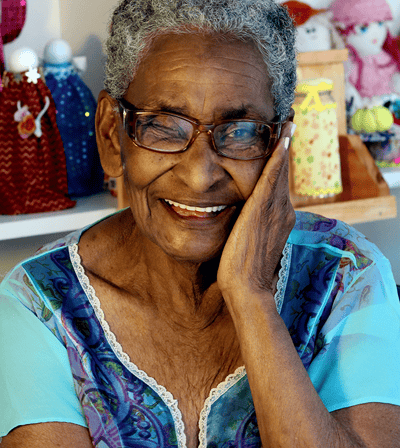 An elderly woman smiling with a colorful background