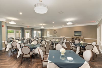 Bright dining room with tables and chairs set up for residents