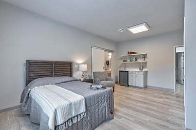 A comfortable and modern resident room with a bed and chair