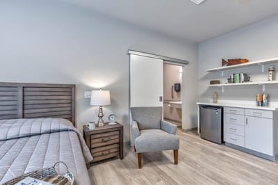 A private resident room with a bed and seating area