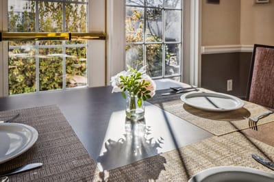 Dining room table set with flowers and placemats