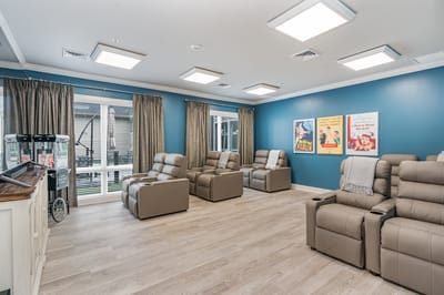 Bright common area with recliner chairs and movie posters