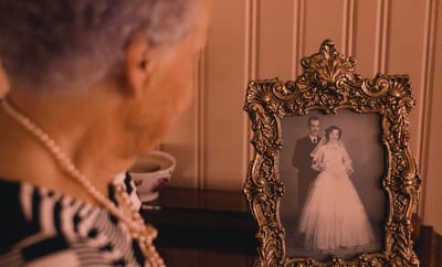 A resident admiring a wedding photo in a vintage frame
