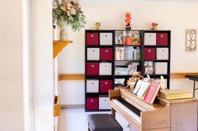Bright interior with piano and shelving unit