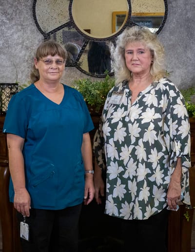 Two staff members posing in a facility common area