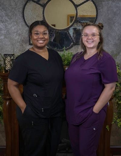 Two caregivers smiling in the facility's common area