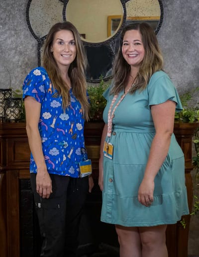Two staff members posing in a facility common area