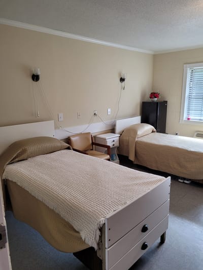 A shared room with two beds and basic furniture