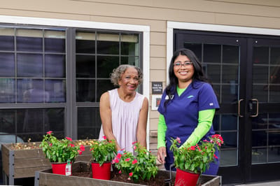 Residents and staff planting flowers in a garden