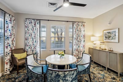 Bright common area with floral curtains and a round table