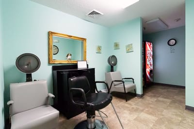 Beauty salon area with chairs and a mirror