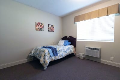 Cozy resident bedroom with floral bedding and window