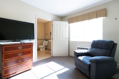 Cozy resident room with chair and TV
