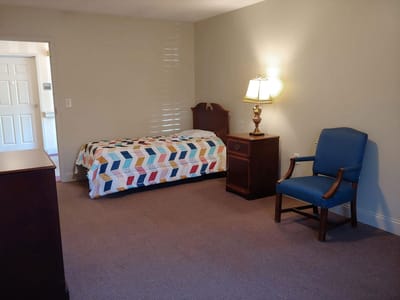 A view of a cozy resident bedroom with a single bed