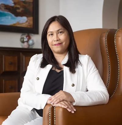 A woman seated in a comfortable chair, smiling