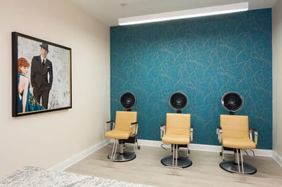 Hair station with three styling chairs in a salon.