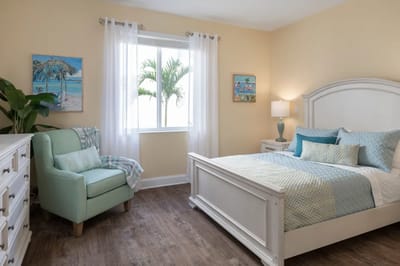 Brightly decorated resident room with plants and artwork