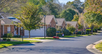 Tree-lined street with brick cottages