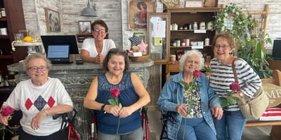 Residents celebrating with roses in an activity area