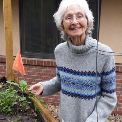 Senior resident smiling while gardening outside