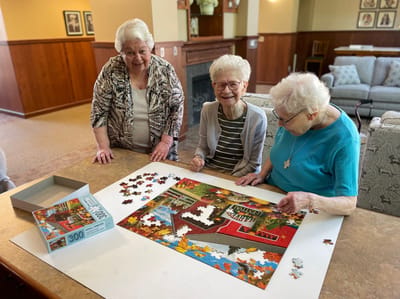 Residents enjoying a puzzle activity in a common area