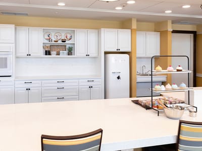 Bright dining area with a dessert display and kitchen appliances