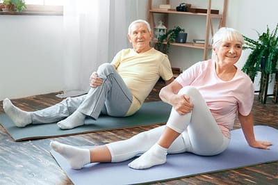 Seniors exercising on yoga mats in a bright room