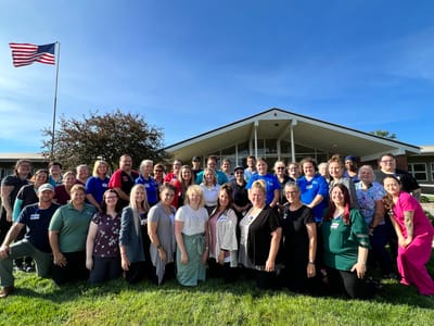 Staff members posing in front of the facility