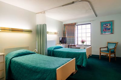 A private resident room with two beds and decor