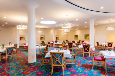 Dining room with colorful decor and tables set for meals