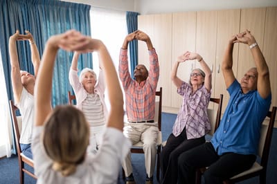 Residents participating in a seated exercise class
