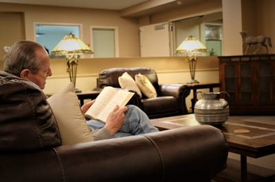 Resident reading in a comfortable common area.