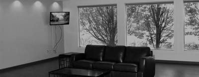 Cozy lounge area with a couch and large windows.