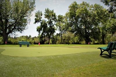 Outdoor putting green with benches and trees