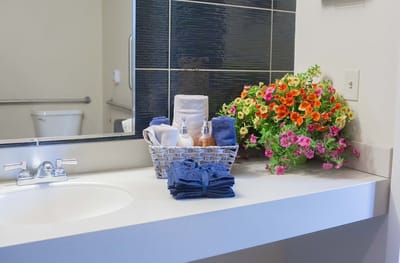 Bathroom countertop with towels and flowers