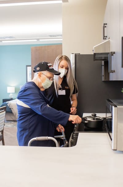 Staff assisting a resident in the kitchen