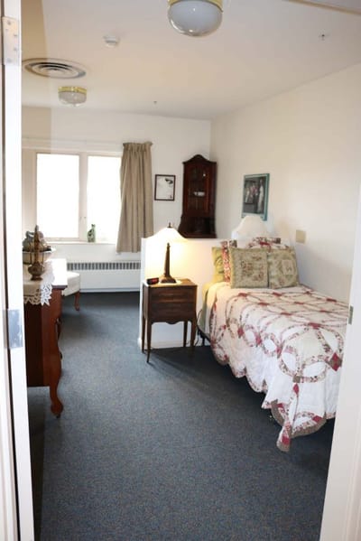 Cozy resident room with a bed and furniture.