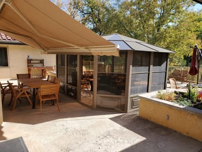 Outdoor seating area with a screened gazebo.