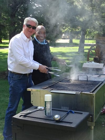 Two staff members grilling outdoors
