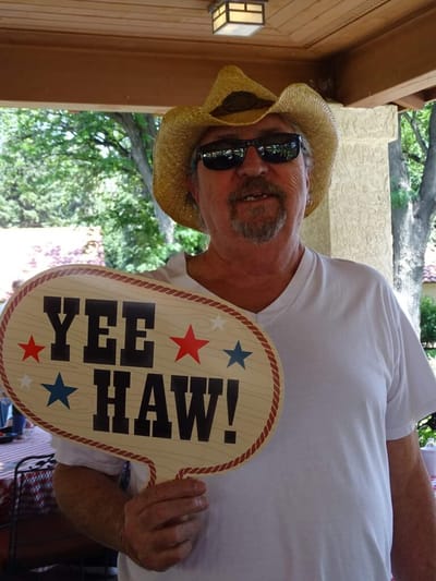 Resident celebrating with a fun sign outdoors.