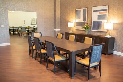 Bright common area with dining table and chairs.