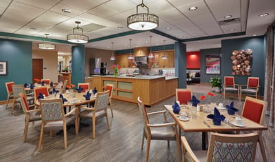 Dining area set up for a meal with tables and chairs.